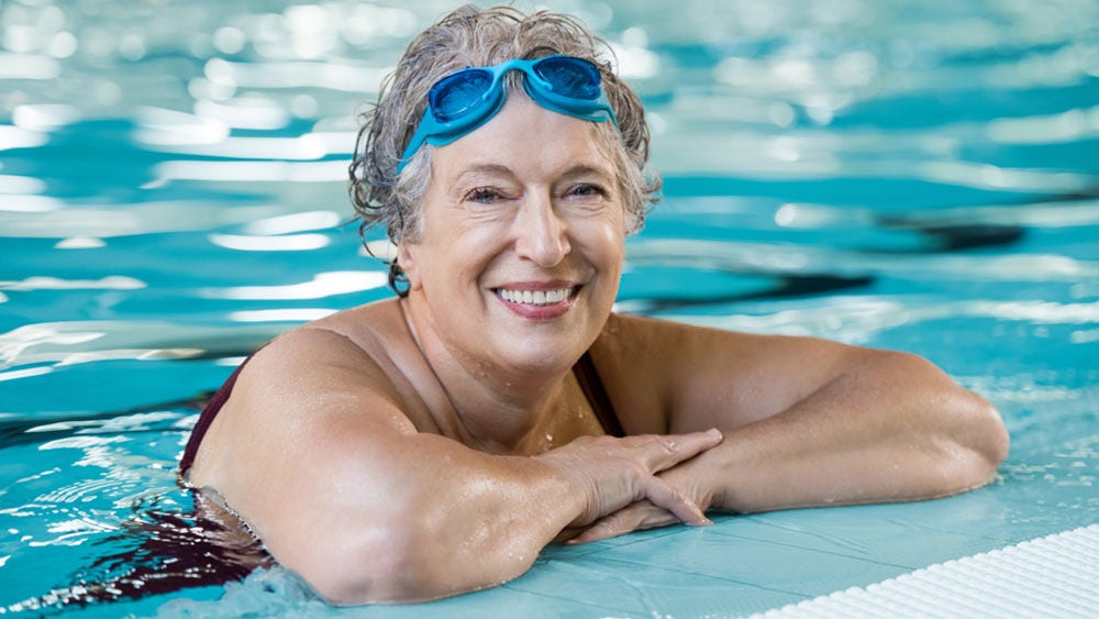 Frau im Schwimmbad mit Schwimmbrille auf der Stirn