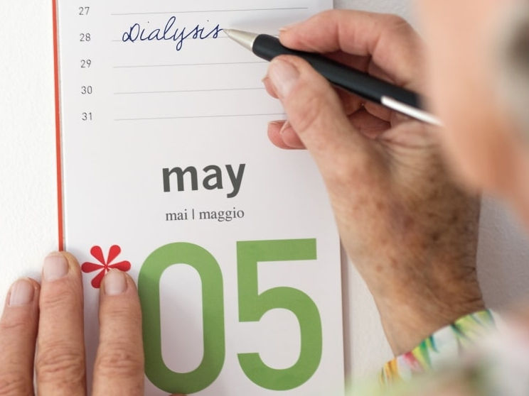 Ältere Frau macht sich Notizen im Kalender